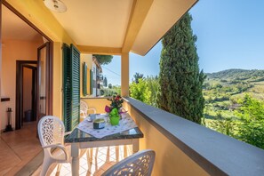 Ein Balkon mit Tisch und Stühlen mit Blick auf eine reizvolle Landschaft.