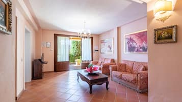 A spacious living room with a sofa, a coffee table, and a chandelier.