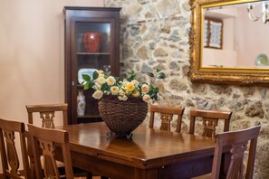 Een eettafel met een gevlochten mand als decoratie, omringd door houten stoelen.