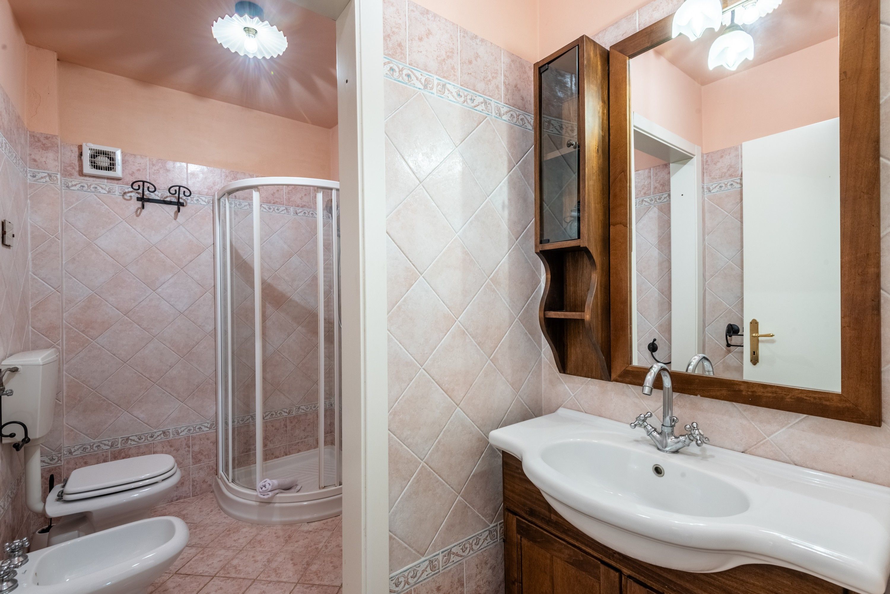 Ein Badezimmer mit Dusche, Toilette, Waschbecken und Spiegel.