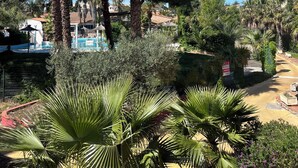 A resort with palm trees, a swimming pool, and a well-maintained garden. - Relaxing vacations (Canet-en-Roussillon)