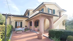 A two-story house with a patio, outdoor seating, and a staircase leading to the upper floor. - Agriturismo I Borghi – Apartment Zenzero with Pool in San Gimignano (San Gimignano)