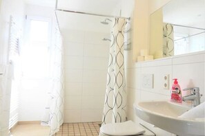 Een douche, een haardroger, handdoeken, toiletpapier