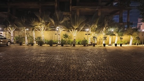 Un cortile lastricato con piante in vaso e luci decorative.