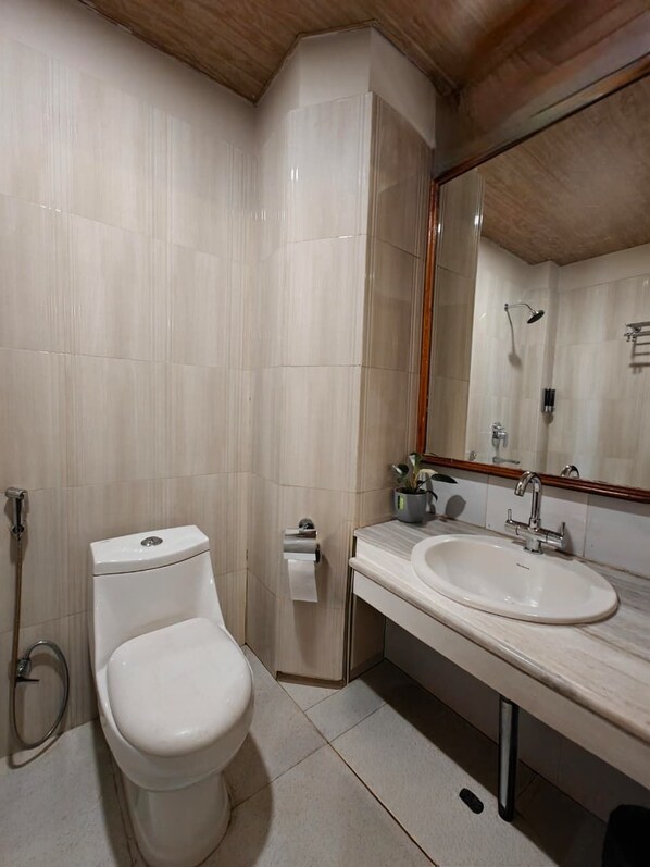 A modern bathroom with a toilet, sink, and shower.
