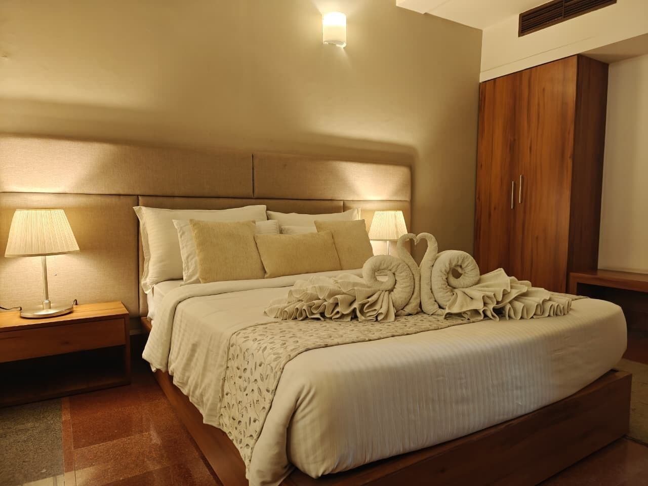 A neatly made bed with a headboard, a bedside lamp, and decorative pillows.
