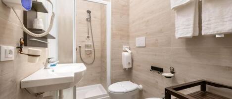Une salle de bain moderne équipée d’une douche, de toilettes et d’un lavabo.