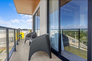 A balcony with two wicker chairs, a wooden ceiling, and a view of the landscape. - NOK Elegant 1BR The Towers by Vistacana (Punta Cana)