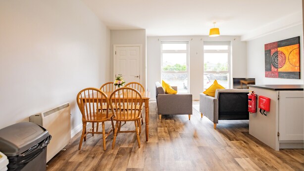A modern living space with a dining area, sofa, and kitchen. - Cozy 2-Bedroom Apartment in Galway (Galway)