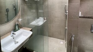 Une salle de bain moderne avec une douche à parois de verre, un lavabo et un miroir.