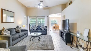 A spacious living room with a grey sofa, a glass coffee table, and a TV on a black stand. - 11 Mi to Disney! Family Haven w/ Poolside Oasis (Davenport)
