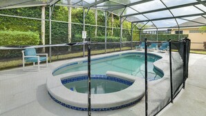 A covered outdoor swimming pool with a hot tub, surrounded by lounge chairs and a safety fence. - 11 Mi to Disney! Family Haven w/ Poolside Oasis (Davenport)