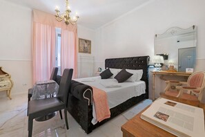 Ein Schlafzimmer mit Bett, Schreibtisch, Stuhl, Tisch und Spiegel.
