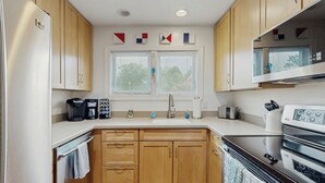 A modern kitchen with wooden cabinets, a stainless steel refrigerator, a double sink, and a black oven. - 5 Blocks to Shore! Rehoboth Beach Family Escape (Rehoboth Beach)