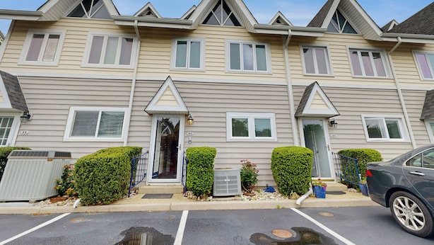 A row of townhouses with a central entrance, air conditioning units, and a parking lot. - 5 Blocks to Shore! Rehoboth Beach Family Escape (Rehoboth Beach)