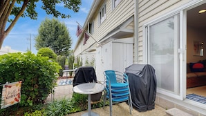 A patio with a table and chairs, a covered grill, and a flag. - 5 Blocks to Shore! Rehoboth Beach Family Escape (Rehoboth Beach)