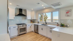 A modern kitchen with white cabinets, a stainless steel stove, and a dishwasher. - Private Pool, Dock & Beach: Stafford Township Gem (Manahawkin)