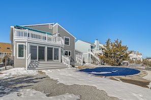A two-story house with a balcony, large windows, and a covered outdoor area. - Private Pool, Dock & Beach: Stafford Township Gem (Manahawkin)
