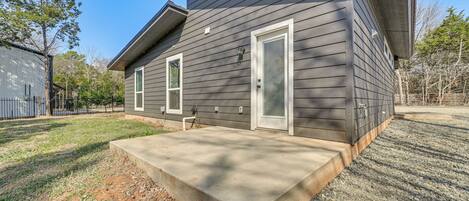 A two-story house with a concrete porch, a garage, and a fenced yard.