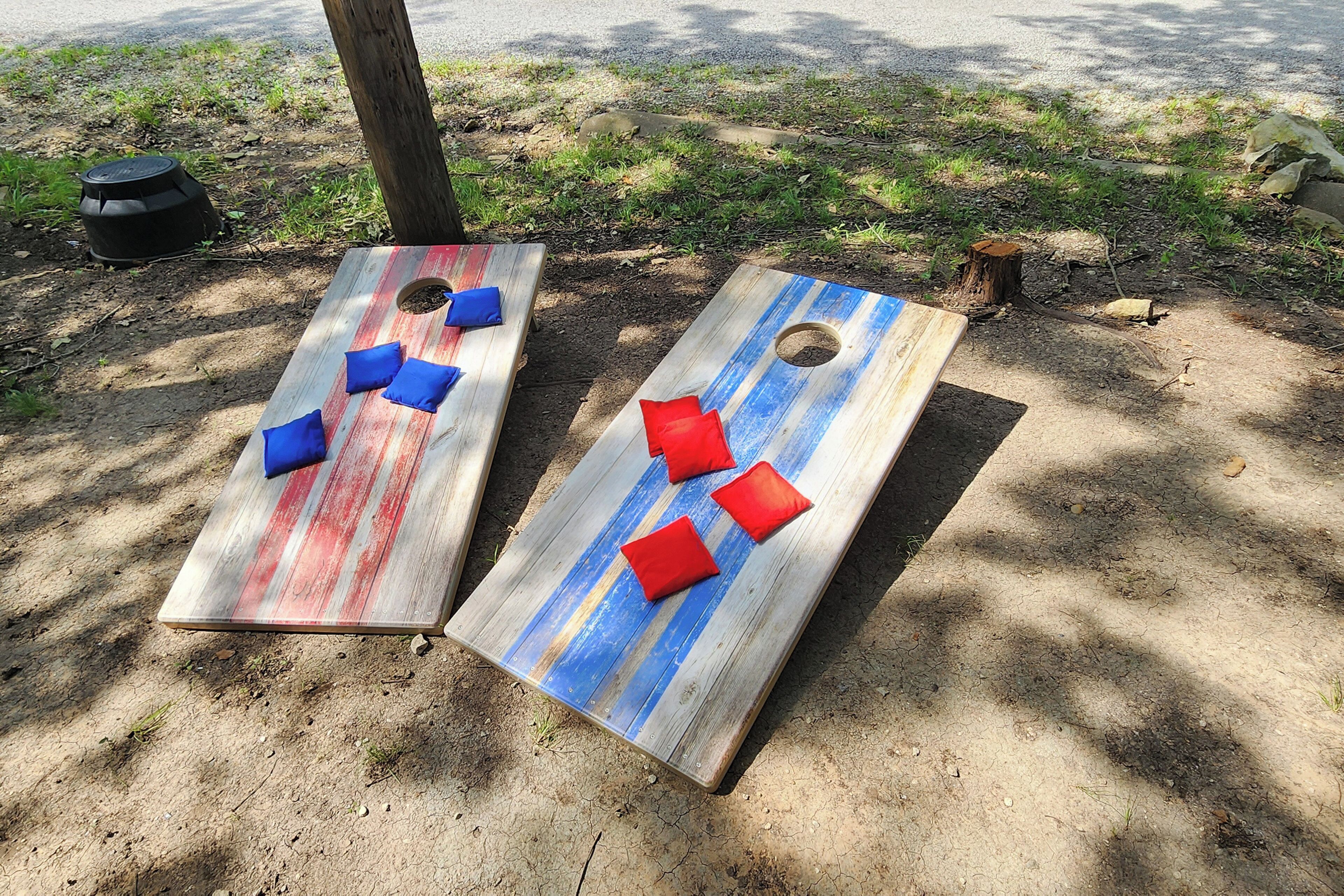 Twee houten plantenbakken met gaten, elk met drie kussens.