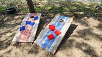 Two wooden planters with holes, each with three cushions.