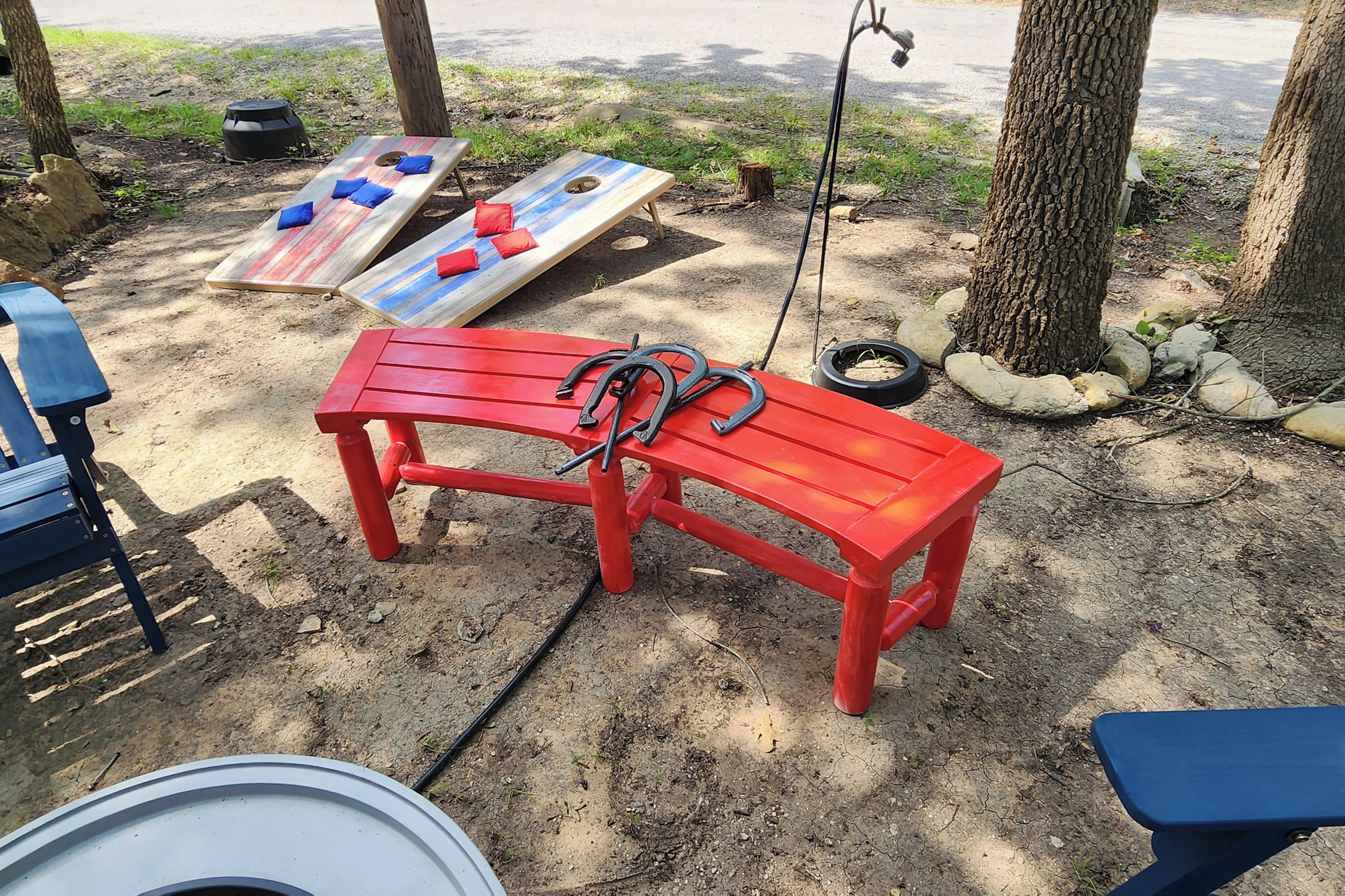 A red bench with a metal frame, a blue bench, and a wooden bench with cushions.