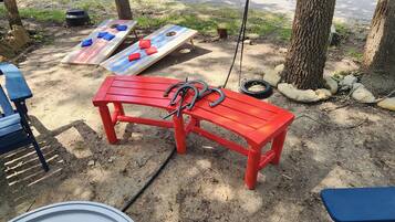 A red bench with a metal frame, a blue bench, and a wooden bench with cushions.