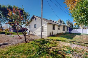 Une maison de plain-pied avec un toit en pente, un garage à l’avant et une pelouse bien entretenue.