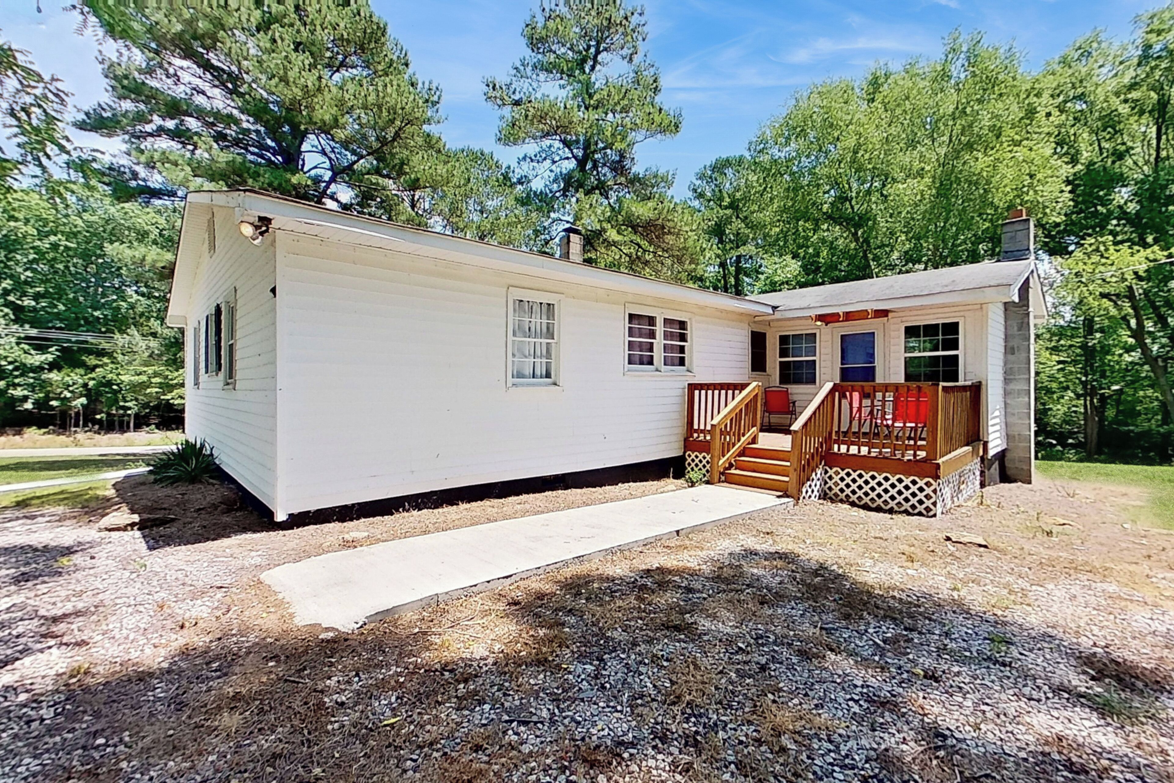 A single-story mobile home with a front porch and a small deck.