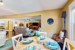 A dining area with a table set for four, a sofa, and a chair in the background. - Private Pool & Hot Tub at Luxe Ringgold Retreat (Ringgold)
