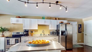 A modern kitchen with white cabinets, stainless steel appliances, and a central island with a fruit bowl. - Private Pool & Hot Tub at Luxe Ringgold Retreat (Ringgold)