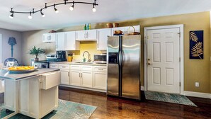 A modern kitchen with white cabinets, stainless steel appliances, and a central island. - Private Pool & Hot Tub at Luxe Ringgold Retreat (Ringgold)