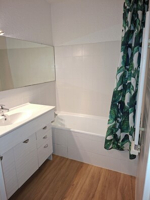 A bathroom with a white sink, mirror, and bathtub. - Near Cannes, with air conditioning, private parking and balcony Pets welcome (Le Cannet)