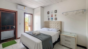 Ein Schlafzimmer mit Bett, Nachttisch und einem an der Wand befestigten Spiegel.