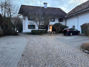 A house with a paved driveway, a mailbox, and a parked car.