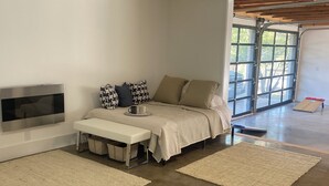 Une chambre à coucher moderne avec un lit, un banc et un téléviseur.