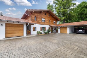 Ein zweistöckiges Haus mit einem Ziegeldach, einer gepflasterten Auffahrt und einer Garage.