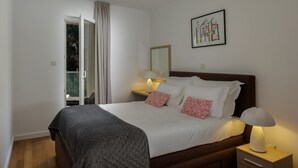 Una camera da letto con un letto, un comodino, una lampada e un quadro appeso al muro.
