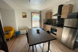 Una cocina moderna con una mesa de comedor, electrodomésticos integrados y vistas al exterior.