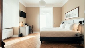 Een slaapkamer met een bed, nachtkastje en bureau met stoel.
