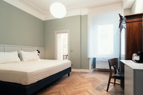 A bedroom with a bed, a desk, and a chair.
