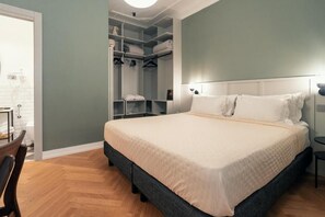 A bedroom with a bed, a wardrobe, and a desk.