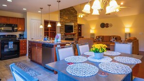 A modern kitchen with a central island, built-in appliances, and pendant lighting.