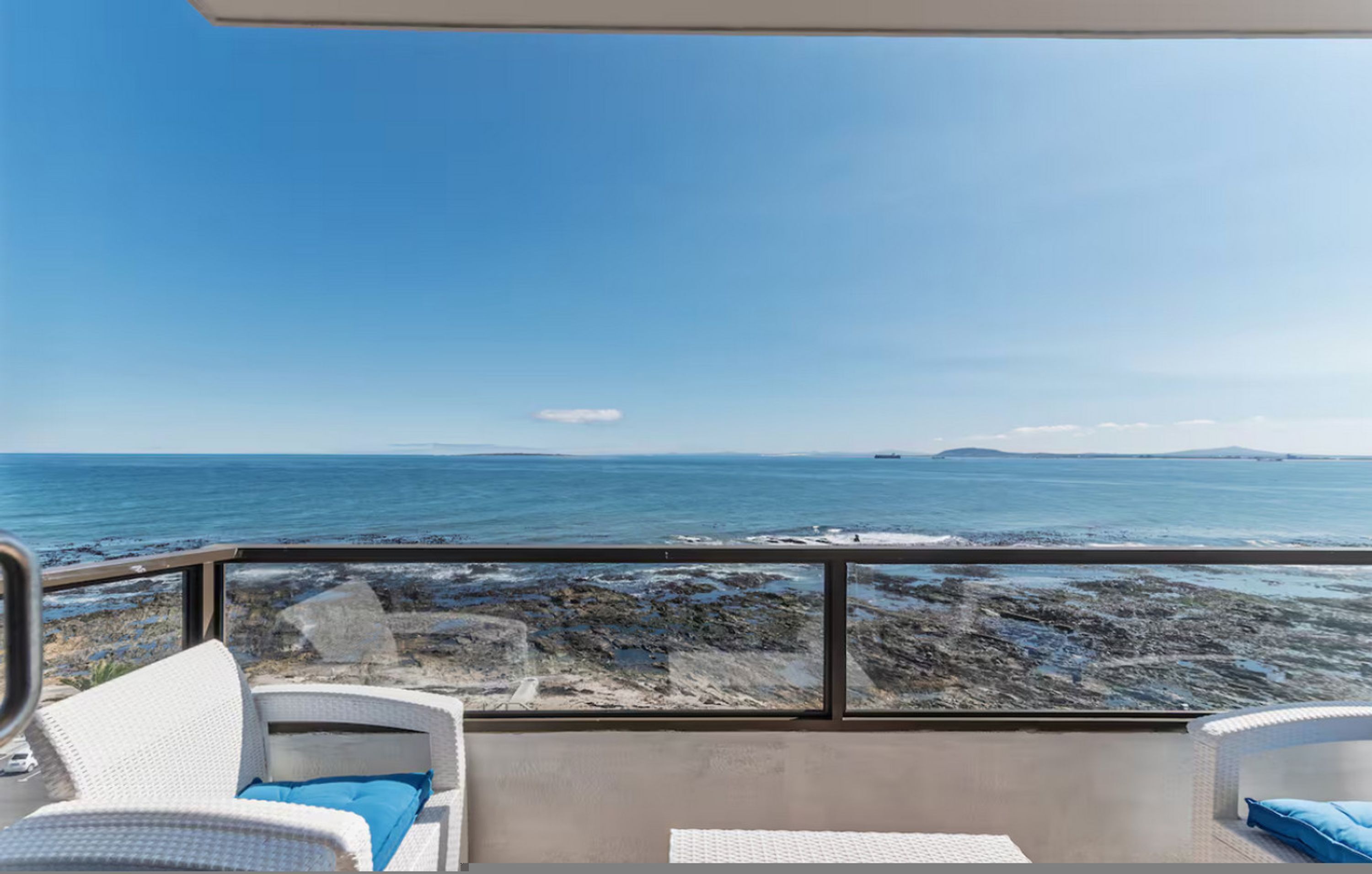 Ein Balkon mit Blick auf das Meer und die felsige Küste.
