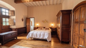 Ein Schlafzimmer mit einem großen Bett, einem Holzschrank und einem Schminktisch.