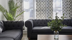 A living room with two dark-colored sofas, a wooden coffee table, and a potted plant. - Modern Home Near Rosemont/allstate Arena O'hare 3 Bedroom Home (Des Plaines)