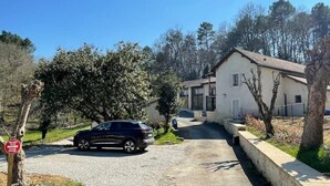 A residential driveway leading to a house with a garage, surrounded by trees and a clear sky. - SIBO GITE apartment 4 pers, swimming pool, nature and city (Boulazac Isle Manoire)