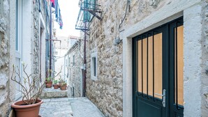 A narrow stone alleyway with a black door, potted plants, and a building with a visible number '9'. - THE OLD WELL ELEGANCE by DuHomes  (Dubrovnik)