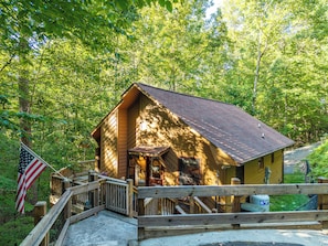 Eine Holzhütte mit Veranda, umgeben von Bäumen.