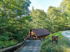 Eine rustikale Holzhütte mit einer Holzterrasse, umgeben von dichtem Wald.